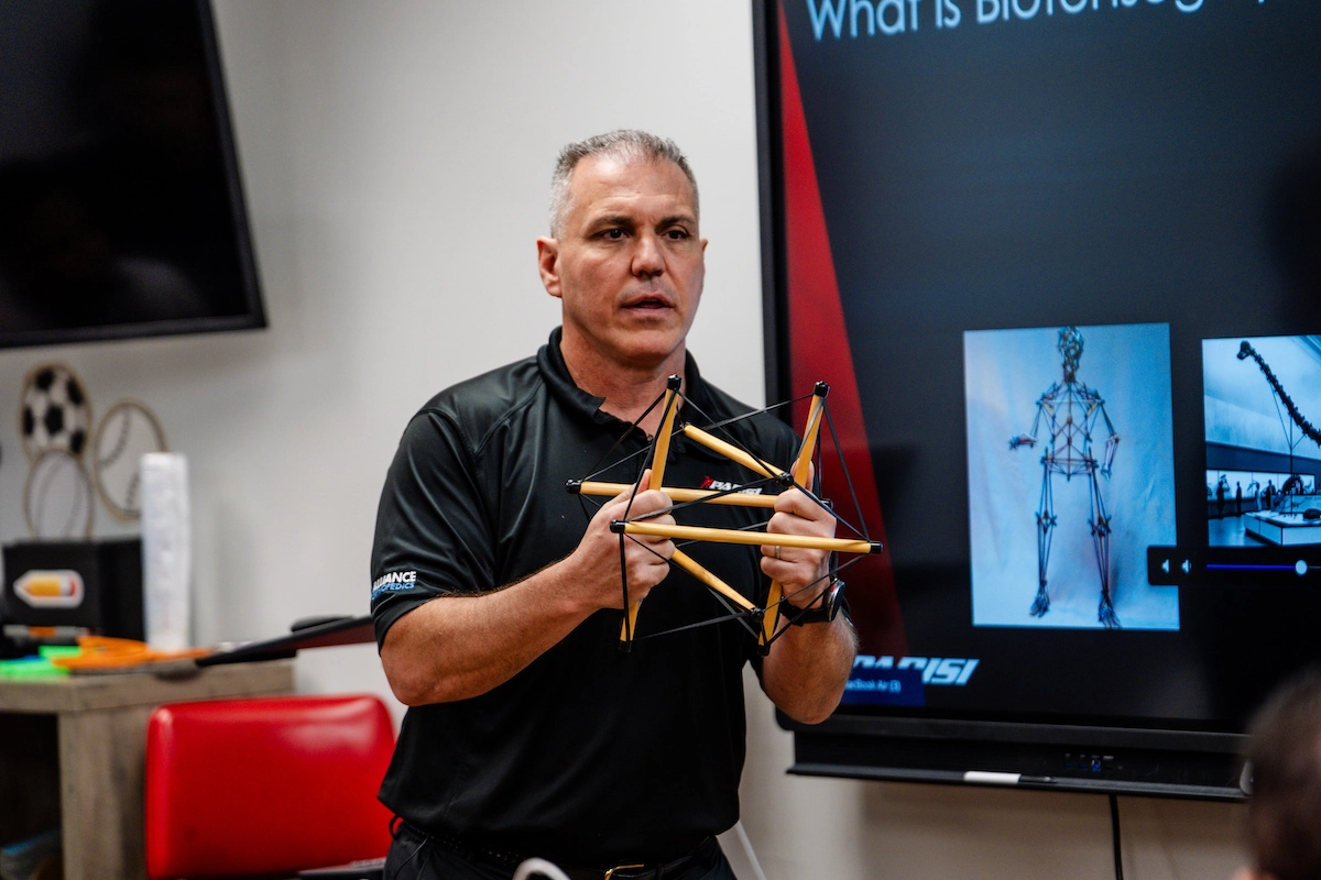 Bill Parisi of Fascia Training Academy holds a model showing the interconnectivity of the human body